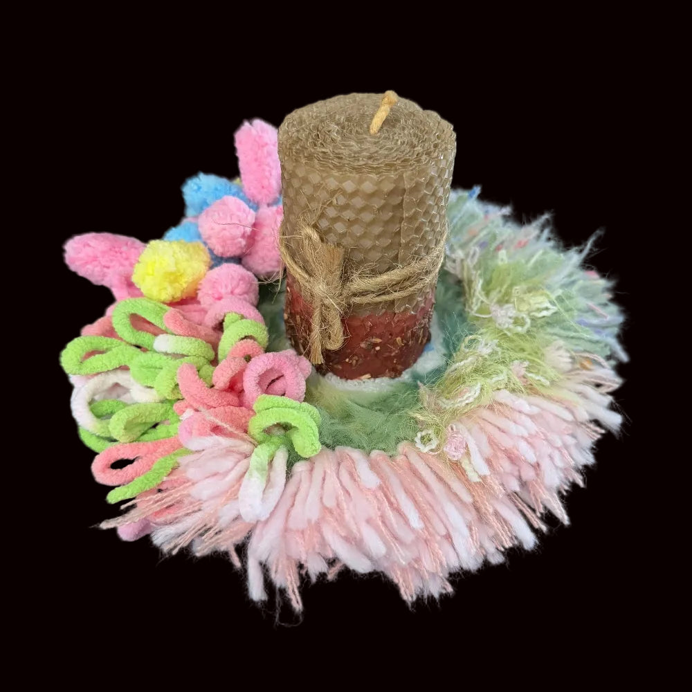 Handmade Blossom Puddle pastel pom-pom crochet coaster styled with beeswax pillar candle on black background, angled lifestyle view – Sylva Garden