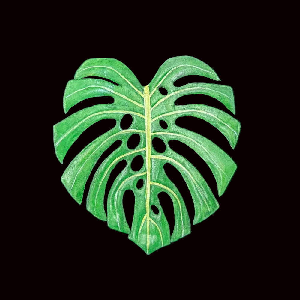 Handmade caladium leaf resin clay fridge magnet in green and pink, flatlay on black background – Sylva Garden