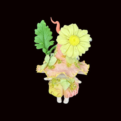 Handmade daisy wisp fairy mushroom resin clay magnet showing magnet backing and sculpted base detail, held by blade on black background 2 – Sylva Garden