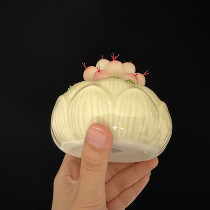 White lotus-shaped ceramic planter base view showing detailed petal relief pattern, held in hand – Sylva Garden