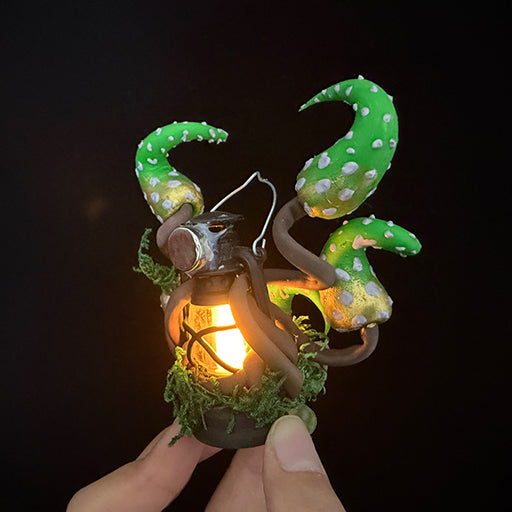 Handmade eldritch tentacle lantern resin clay magnet with glowing lantern held in hand, front view on black background – Sylva Garden