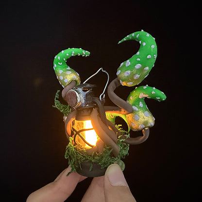 Handmade eldritch tentacle lantern resin clay magnet with glowing lantern held in hand, front view on black background – Sylva Garden