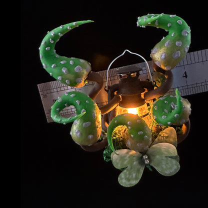 Handmade eldritch tentacle lantern resin clay magnet with glowing light and size reference ruler, overhead view on black background – Sylva Garden