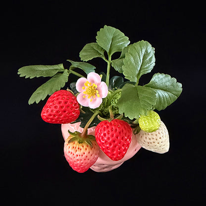 Handmade clay strawberry arrangement angled top view showing layered red white and green clay strawberries with pink blossom and green leaves in pink strawberry ceramic pot – Sylva Garden