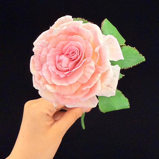 Handmade resin clay pink rose close-up showing hand-sculpted layered petals and green leaf detail – Sylva Garden