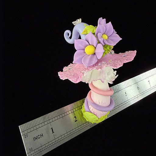 Handmade mauve curl fairy mushroom resin clay magnet showing purple daisy flowers yellow leaf and crystal butterfly detail, overhead view with ruler approx 2 inches – Sylva Garden
