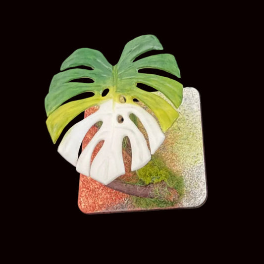 Handmade monstera leaf resin clay fridge magnet with moss base, overhead view on black background – Sylva Garden
