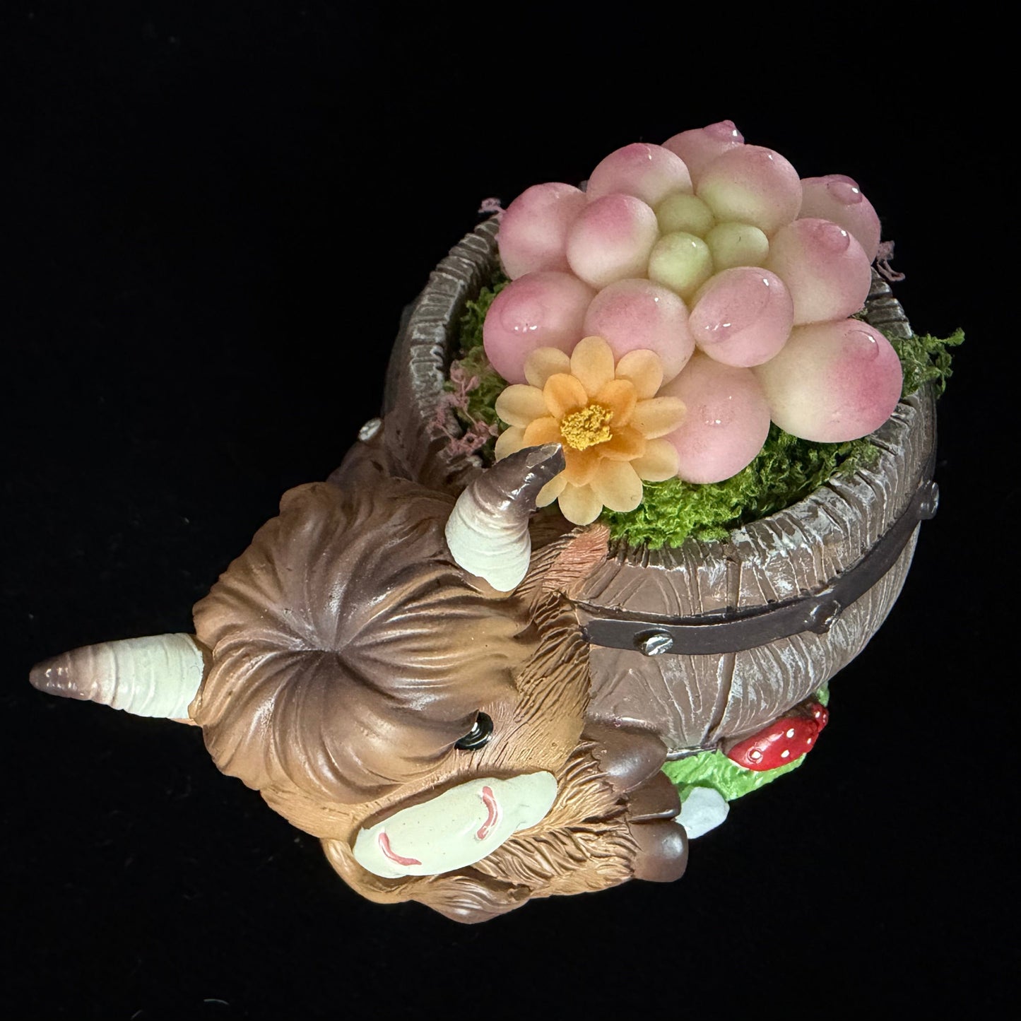 Handmade highland cow resin planter angled back top view showing pink Peach Girl succulent cluster orange flower green moss and red mushroom base detail – Sylva Garden