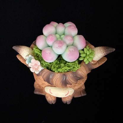 Handmade highland cow resin succulent planter top view showing pink green clay succulent crown arrangement with small flower accent and horns – Sylva Garden