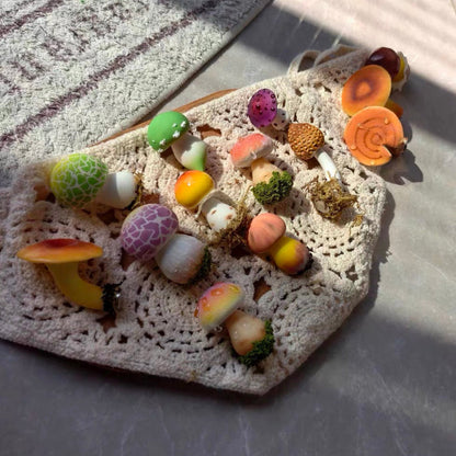 Full collection of handmade mushroom resin clay fridge magnets displayed on crochet mat, colorful cottagecore mushroom designs – Sylva Garden