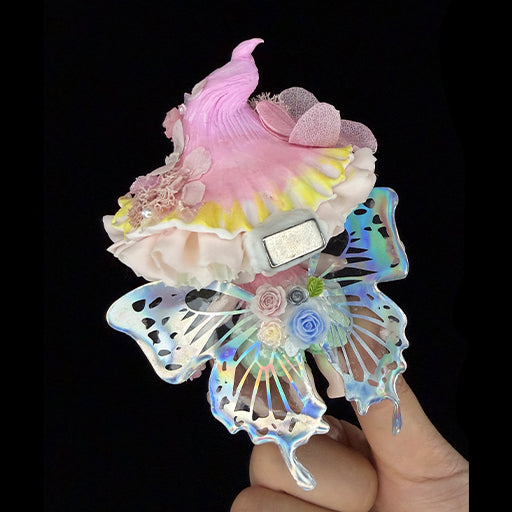 Handmade petal wing butterfly resin clay fridge magnet held in hand showing back with magnet and holographic wing detail on black background – Sylva Garden