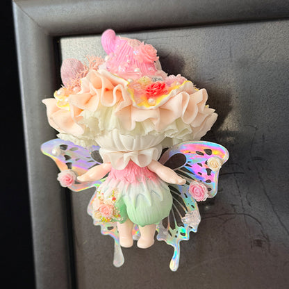 Handmade petal wing butterfly resin clay fridge magnet with holographic wings and pink rose details attached to grey metal door, lifestyle view – Sylva Garden