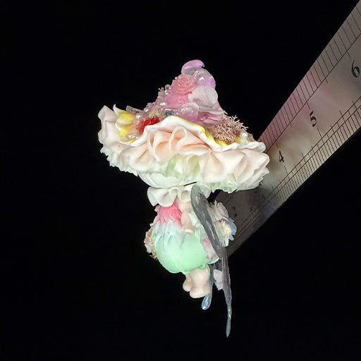 Handmade petal wing butterfly resin clay fridge magnet side angle view showing ruffled mushroom cap and holographic wing spread with ruler for scale on black background – Sylva Garden