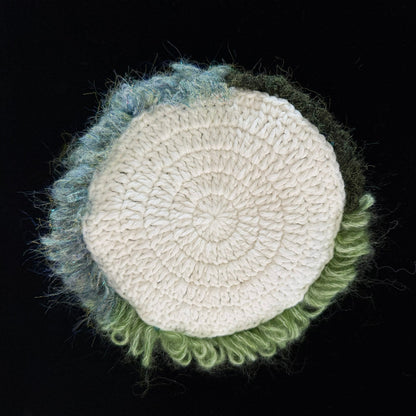 Handmade Pixie Ring red lace mushroom crochet moss coaster back view showing cream white crochet base with blue green moss border on black background – Sylva Garden