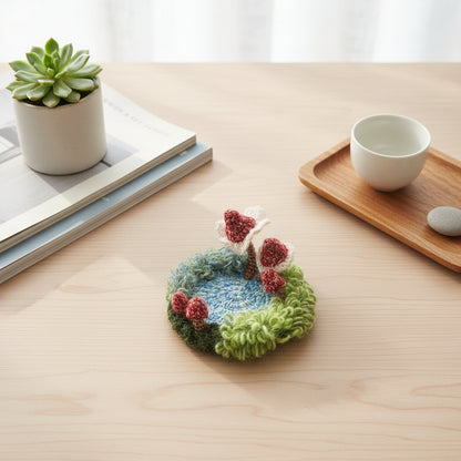 Handmade Pixie Ring red lace mushroom crochet moss coaster styled with succulent plant ceramic tea cup and wooden tray on light wood desk, lifestyle view – Sylva Garden