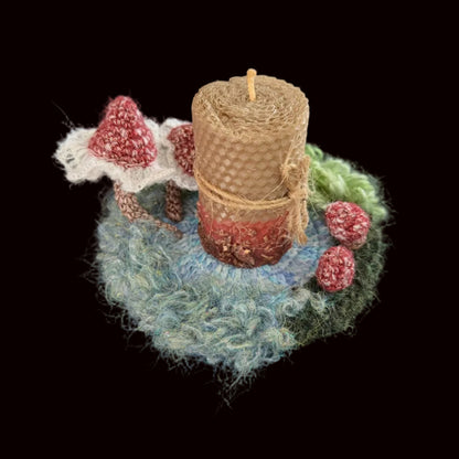 Handmade Pixie Ring red lace mushroom crochet moss coaster styled with beeswax pillar candle on black background, angled side view – Sylva Garden