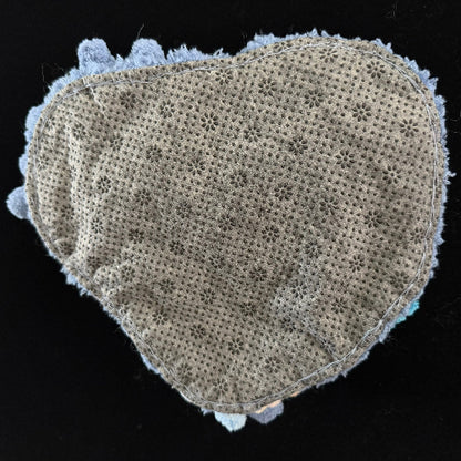 Handmade Tidal Moss blue white gradient pom-pom crochet coaster back view showing beige floral lace fabric base with light blue pom-pom border on black background – Sylva Garden