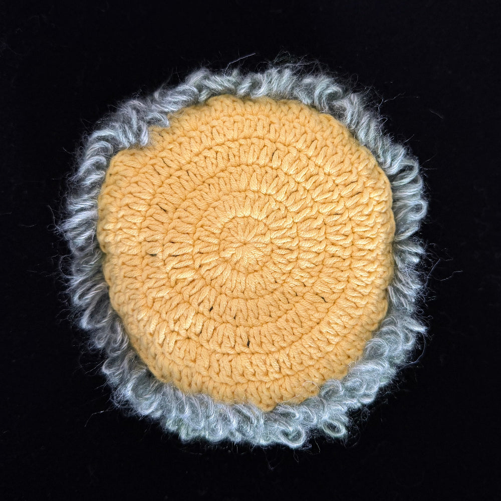 Handmade Violet Veil purple mushroom crochet moss coaster back view showing golden yellow crochet base with light grey blue moss border on black background – Sylva Garden