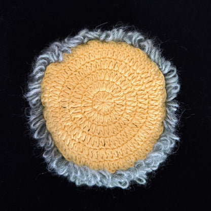 Handmade Violet Veil purple mushroom crochet moss coaster back view showing golden yellow crochet base with light grey blue moss border on black background – Sylva Garden