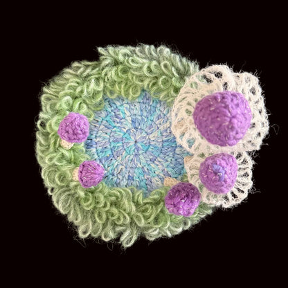 Handmade Violet Veil purple mushroom crochet moss coaster close-up overhead view showing detailed white lace veil fringe and purple textured mushroom caps on black background – Sylva Garden