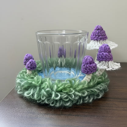Handmade Violet Veil purple mushroom crochet moss coaster in use with clear ribbed glass on wooden table, showing lace veil mushroom caps and green moss texture – Sylva Garden