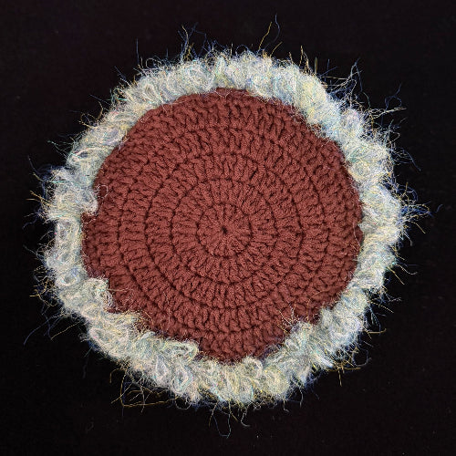 Handmade Whisper Cap ivory lace mushroom crochet moss coaster back view showing terracotta brown crochet base with cream moss border on black background – Sylva Garden